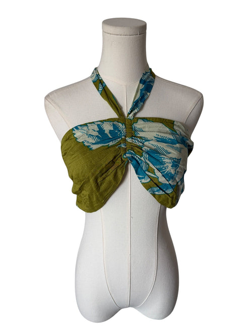 Green and blue patterned scarf tied around a mannequin on a white background