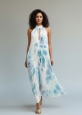 Woman wearing a blue and white tie-dye dress on a plain background