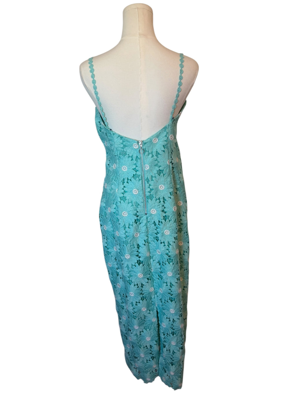 A turquoise blue sleeveless maxi dress with a delicate white floral pattern, displayed on a cream mannequin against a white background.