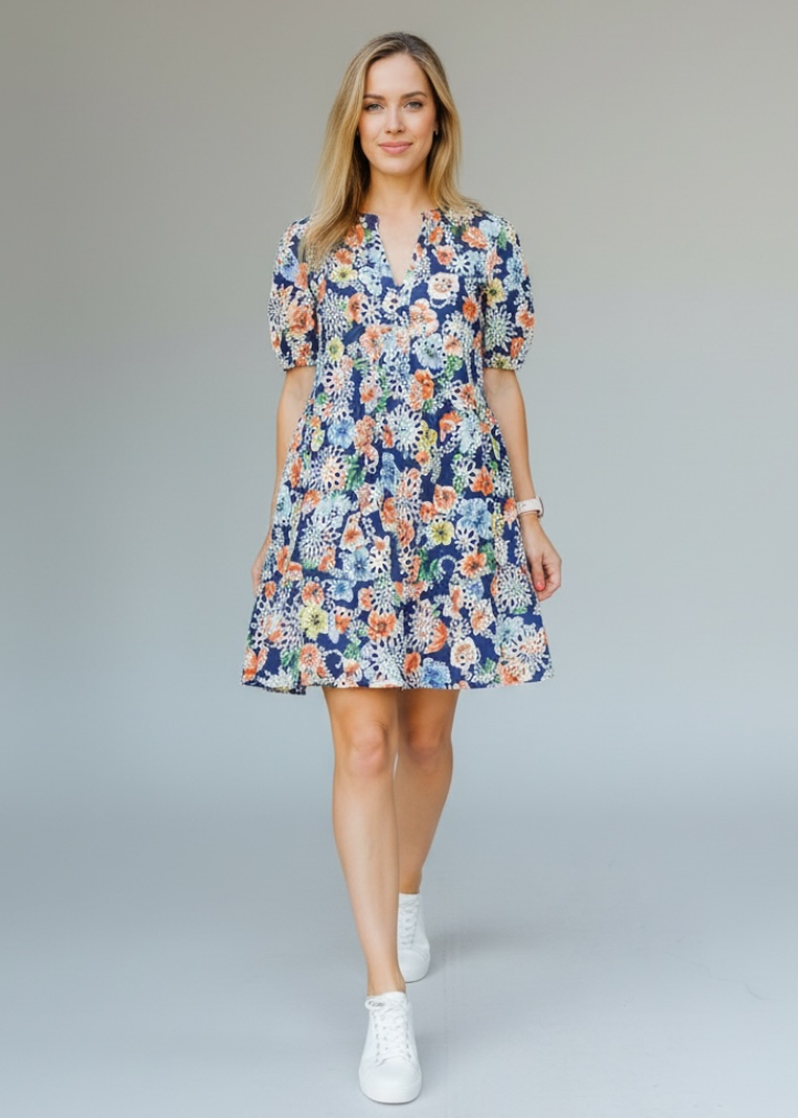Woman wearing a floral dress on a plain background