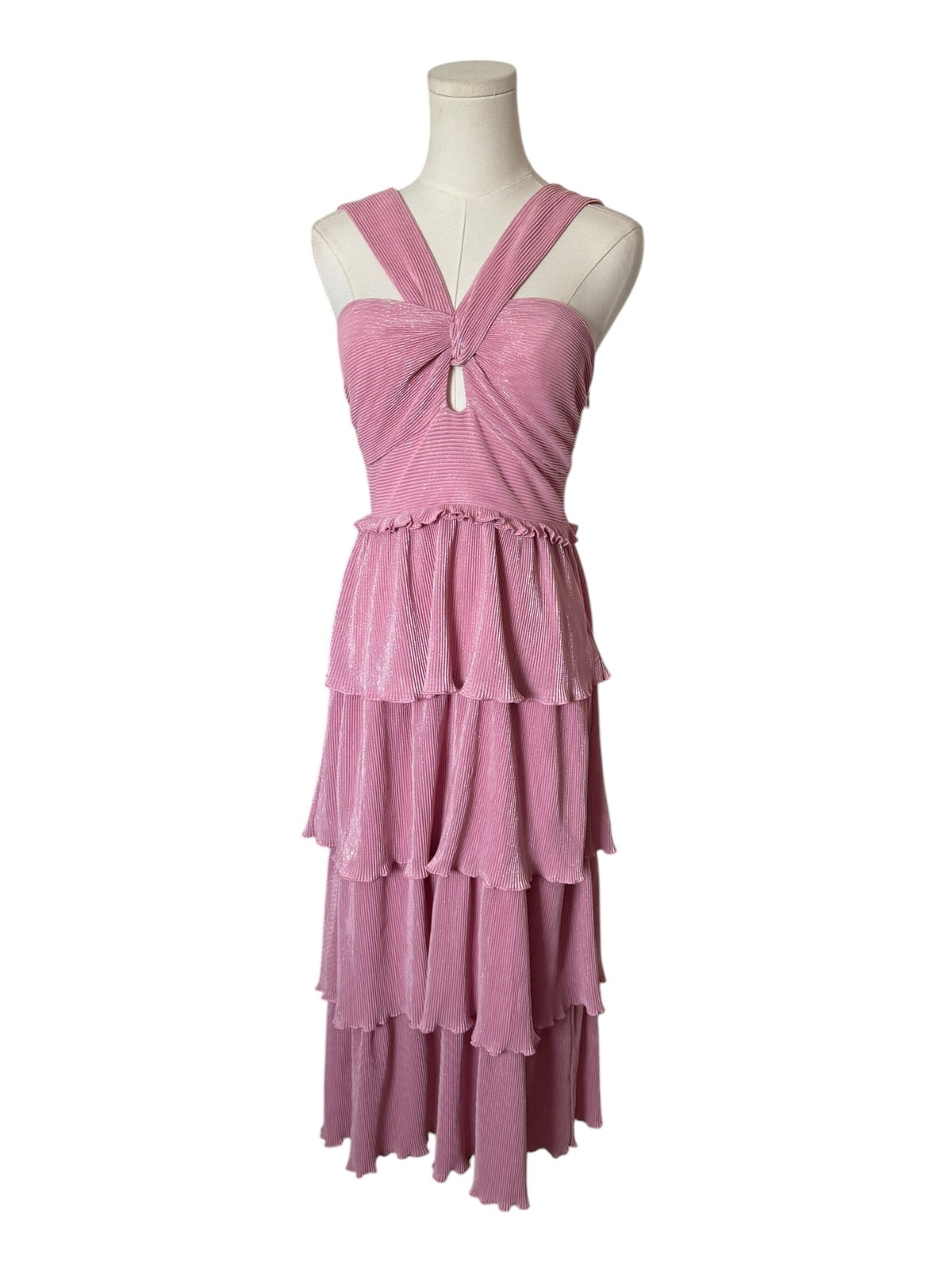 A sleeveless dusty pink tiered dress with a crossover halter-style neckline and a small front cutout, displayed on a mannequin torso against a plain white background.